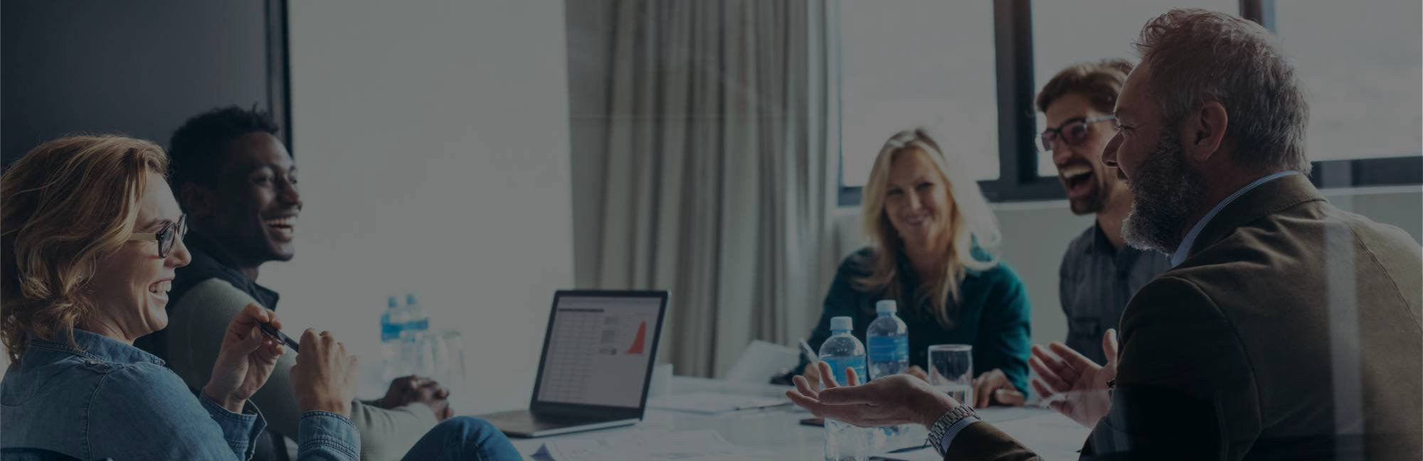 Hintergrundbild NEO - Mitarbeiter mit Notebook am Tisch